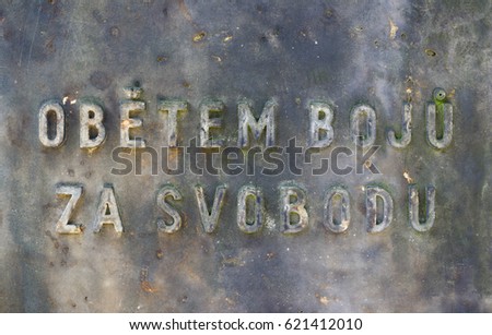 Obetem boju za svobodu (To victims of fights for freedom) - czech text on war memorial. Faded monument is made of raw and rugged material
