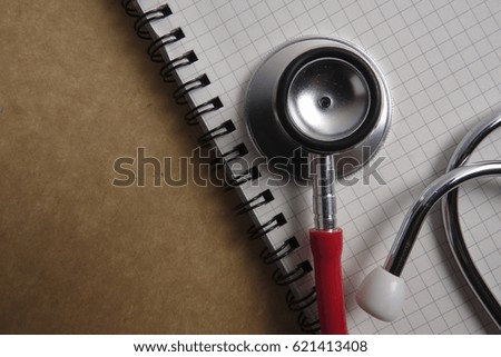 Red stethoscope on wooden background. Medical and health care concept.