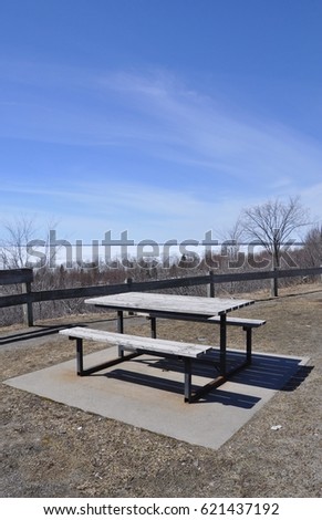 Picnic table overlooking a frozen lake with blue skies