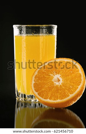 Glass of orange juice isolated on black