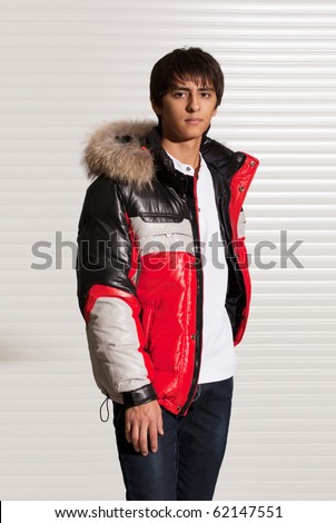 Portrait of a handsome young man of sixteen. Youth shows autumn, winter clothing.