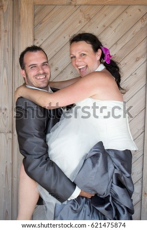 Wedding couple cuddling under wooden background