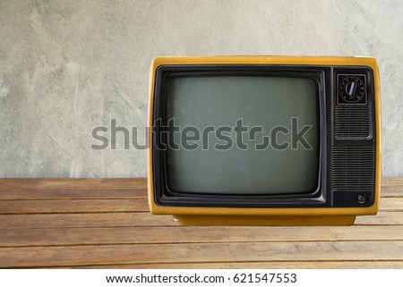 Old vintage television on wood desk background