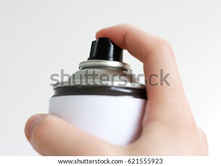 Man's hand holds a spray of black paint. Isolated on a white background