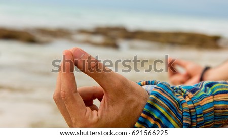 Caucasian man practicing yoga at seashore. Close-up.
