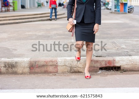 Business woman walking across the crosswalk