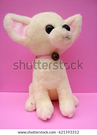 dog doll on pink background.