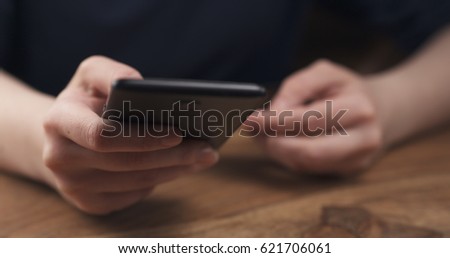young female teen hand using smatphone sitting at the table closeup, 4k photo