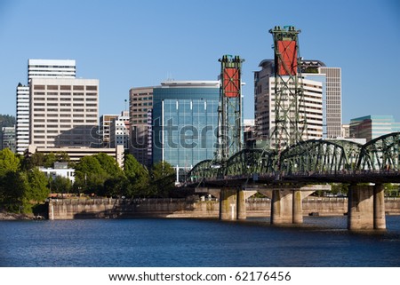 Portland Oregon skyline with Hawthorne bridge crossing the Willamette river under clear blue sky