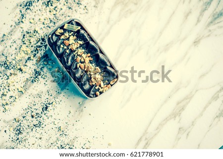 Cream cake with nuts and chocolate powder on rustic background.
