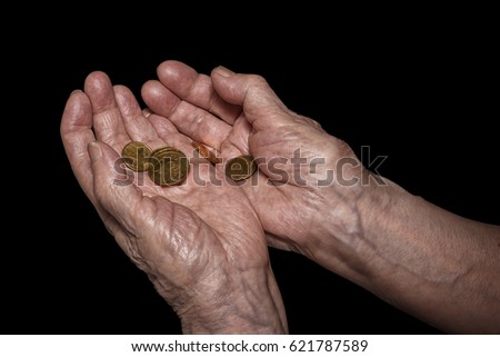 Senior woman hands holding some euro coins. Pension, poverty, social problems and senility theme. Isolated on black, clipping path included Royalty-Free Stock Photo #621787589