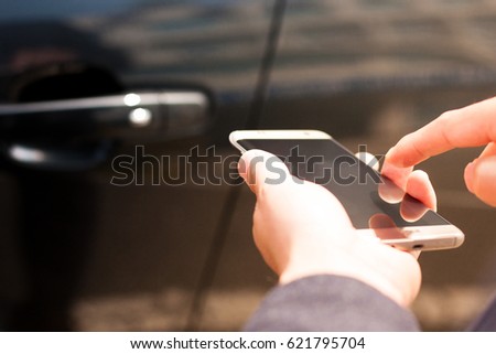 Opening and closing car door with smart phone / Automobile, IT, information communication Royalty-Free Stock Photo #621795704