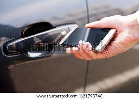 Opening and closing car door with smart phone / Automobile, IT, information communication Royalty-Free Stock Photo #621795746