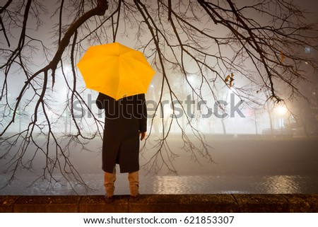 Man with umbrella at night walking on the street