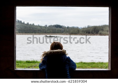 A girl looks out upon the Cabell Marsh from the gazebo in the William L Finley National Wildlife Refuge. Royalty-Free Stock Photo #621859304