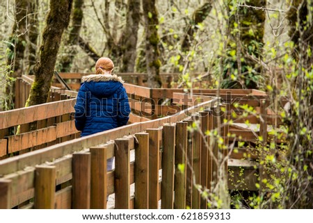 A girl walks along the Muddy Creek Boardwalk in the William L Finley National Wildlife Refuge. Royalty-Free Stock Photo #621859313