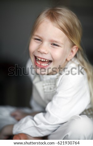 A girl of preschool age laughs cheerfully. Portrait of a happy child, carefree childhood. Healthy teeth
