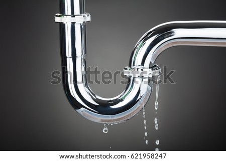 Leakage Of Water From Stainless Steel Pipe On Gray Background Royalty-Free Stock Photo #621958247