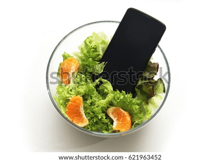 Smartphone in the salad. Symbol of dependence on social networks, putting pictures of food in social networks.  illustration of calorie counting using gadgets, diet, proper nutrition.