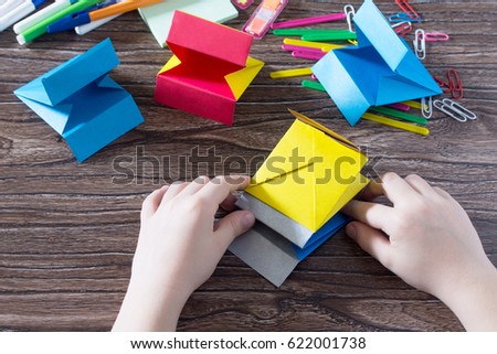 The child puts the modules. The project of children's creativity is a children's office organizer made of paper, origami crafts, handicrafts for children. Handmade.