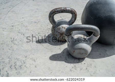 Gym kettlebell weight and medicine ball. Closeup of grunge background weights on concrete floor. Fitness and a healthy lifestyle