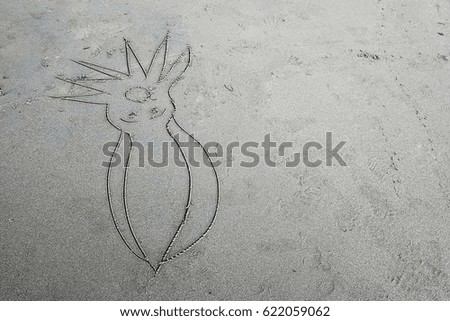 Children draw squid on the sand beach.