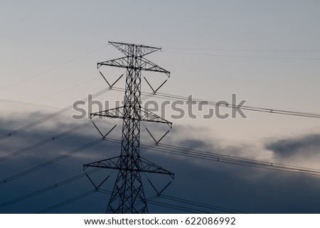 Electricity transmission power lines (High voltage tower) during sunset with dark sky