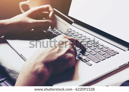 Man holding credit card and typing laptop for online shopping.