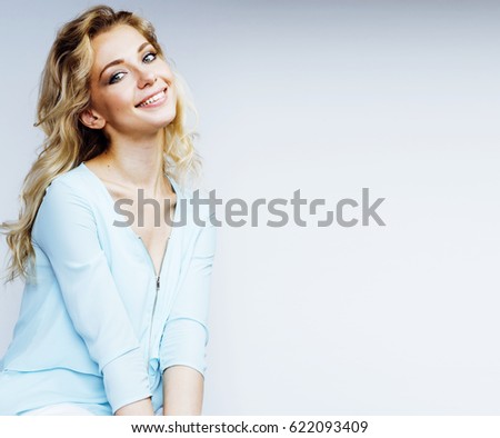 young pretty blond woman smiling on white background close up makeup blue dress