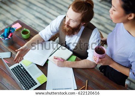 Two young designers discussing online information