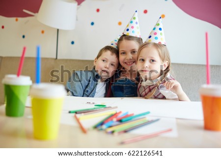 Affectionate kids having birthday party in cafe