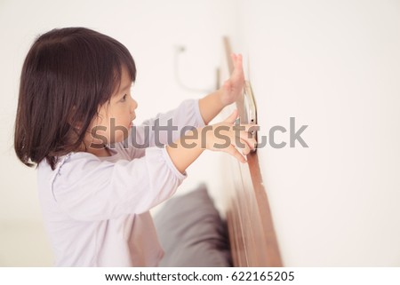 child girl happy look smart phone. asian child.Child development.Little asian girl look smart phone on the bed.