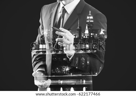 Guy in suit drawing something on abstract city background. Art concept. Double exposure
