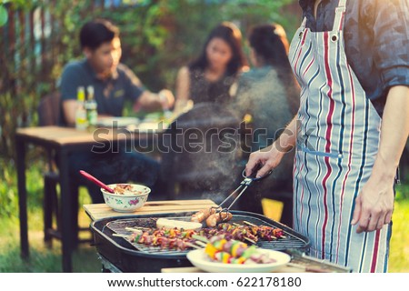 Asian men are cooking for a group of friends to eat barbecue Royalty-Free Stock Photo #622178180