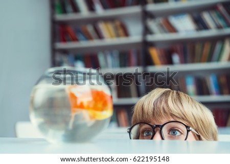 Little boy with goldfish in library
