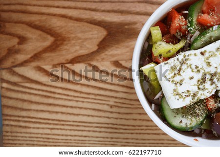 Fresh vegetable traditional Greek salad made of natural white low fat feta cheese,sliced cucumber & tomato,olives & spices.Eat healthy delicious food.Top view with copy space