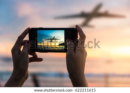 Silhouette of female to take the photo the landscape of sunset with Plane viewpoints in Phuket at Nai Yang Beach, Phuket Province, Thailand.
