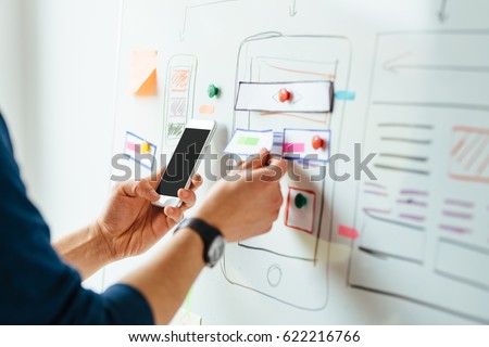 Web designer planning application for mobile phone Royalty-Free Stock Photo #622216766