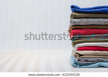 Folded men's clothing on stripy background Royalty-Free Stock Photo #622244228