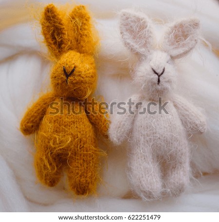 Yellow and white rabbits lie on the wool