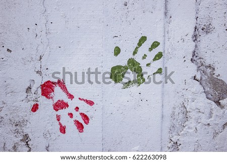 White concrete wall with colorful multi colored handprint .