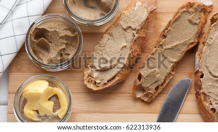 Bread with veal and rabbit pate with butter on a bamboo board. Top view