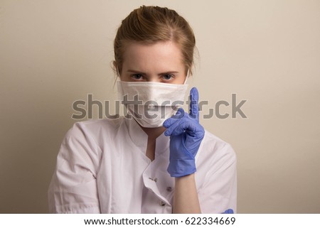 I think, idea , Portrait of a female doctor in a bathrobe, medical gloves on a light background woman doctor with a medical bandage on her face