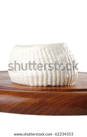 soft light round cheese on cutting plate
