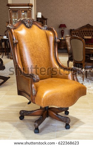 Classic leather armchair in a furniture store. Brown luxurious armchair in the interior of a shop.