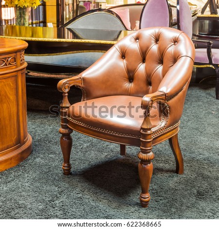 Classic leather chair in a furniture store. Brown armchair in the interior of a shop.