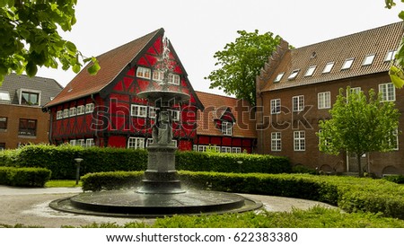 Colorful townhouse with an old fountain in the foreground, Aalborg, Denmark Royalty-Free Stock Photo #622383380