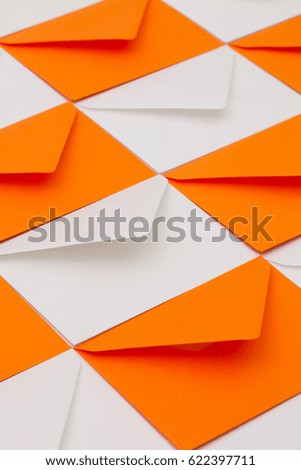 Composition with white and orange envelopes on the table.