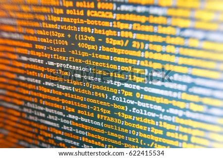Website HTML Code on the Laptop Display Closeup Photo. CSS, JavaScript and HTML usage. PHP syntax highlighted. Software engineer at work. Software abstract background. SEO concepts for better SERP. 
