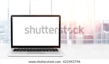 Laptop on table in office with panoramic view of modern downtown skyscrapers at business district